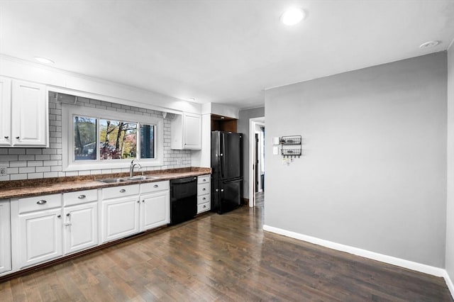 kitchen featuring backsplash, dark countertops, a sink, baseboards, and black appliances