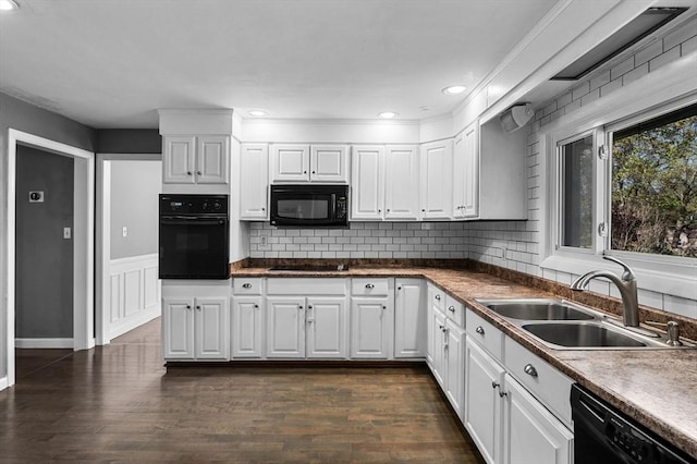 kitchen featuring a sink, black appliances, white cabinetry, and dark wood-type flooring