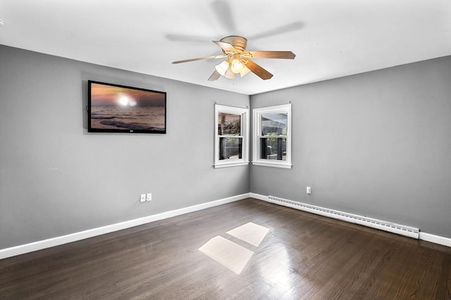 spare room featuring ceiling fan, a baseboard heating unit, dark wood-style floors, and baseboards