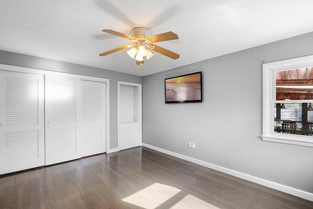 unfurnished bedroom with baseboards, a ceiling fan, wood finished floors, and a closet