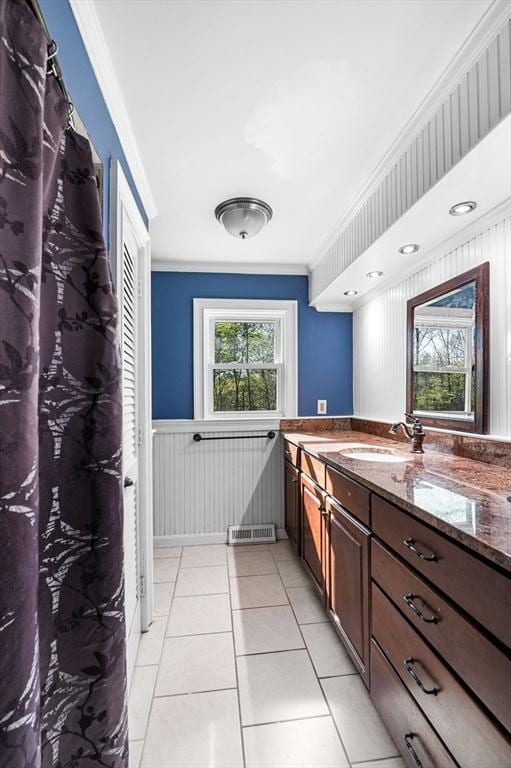 full bathroom featuring crown molding, tile patterned floors, a wainscoted wall, and vanity