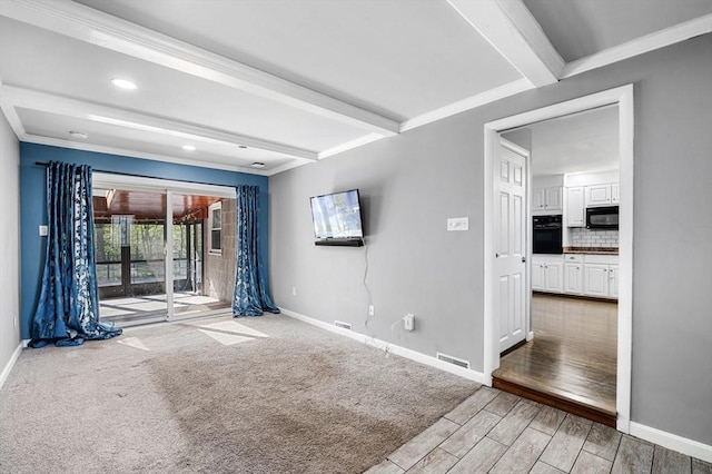 empty room featuring baseboards, recessed lighting, wood finished floors, and beamed ceiling