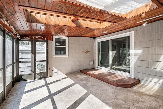 unfurnished sunroom featuring a skylight