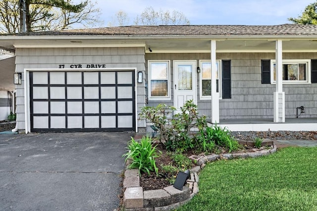 view of front of home with a garage, driveway, a shingled roof, and covered porch