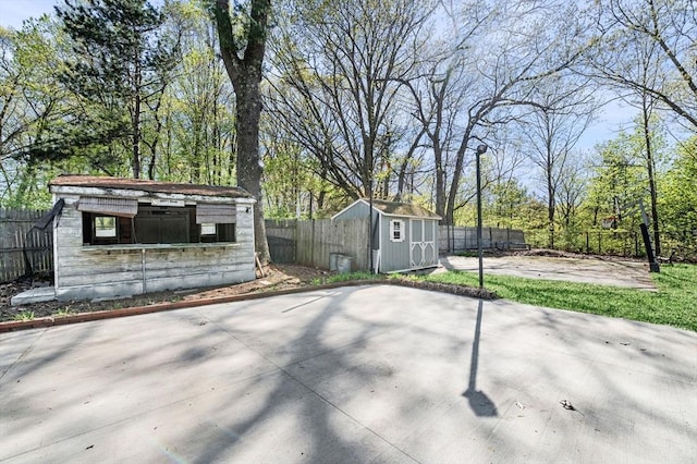 view of patio / terrace with a fenced backyard, a shed, and an outbuilding