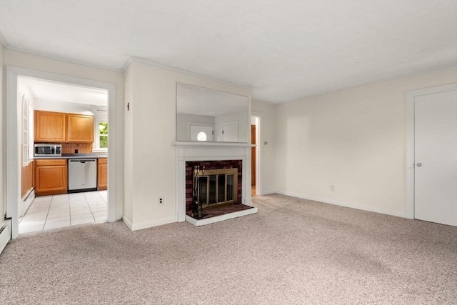 unfurnished living room featuring light colored carpet, a fireplace, baseboards, and ornamental molding