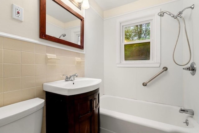 bathroom with toilet, vanity, backsplash, tub / shower combination, and tile walls