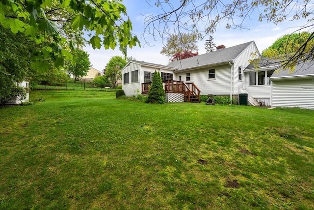 view of grassy yard with a wooden deck