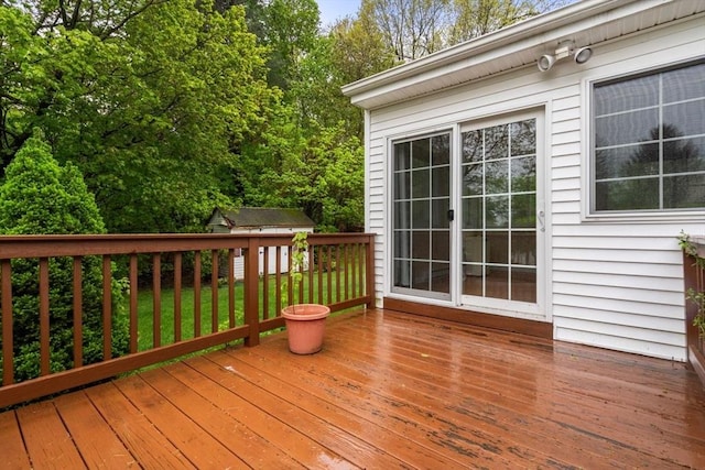 wooden terrace with an outdoor structure and a storage shed
