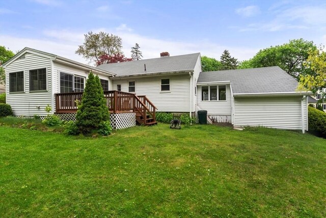 back of property featuring a deck, a yard, a chimney, and roof with shingles