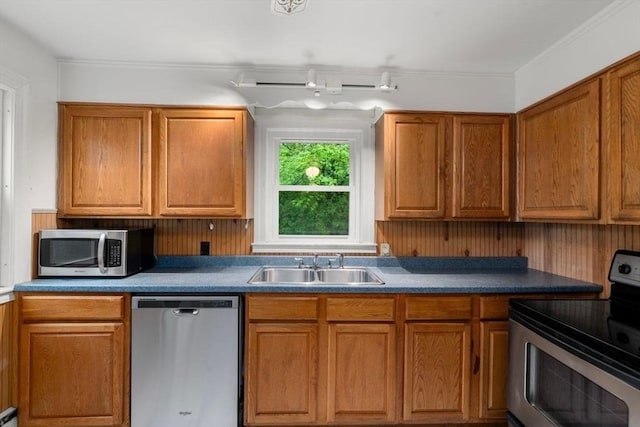 kitchen with stainless steel appliances, a sink, and brown cabinetry