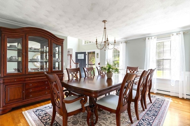 40 King Philip Dr, Rehoboth, MA 02769 - dining area featuring a textured ceiling, crown molding, a chandelier, light wood-style floors, and a baseboard heating unit