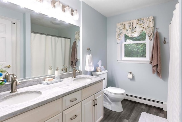 40 King Philip Dr, Rehoboth, MA 02769 - full bathroom with a baseboard heating unit, double vanity, wood finished floors, toilet, and curtained shower
