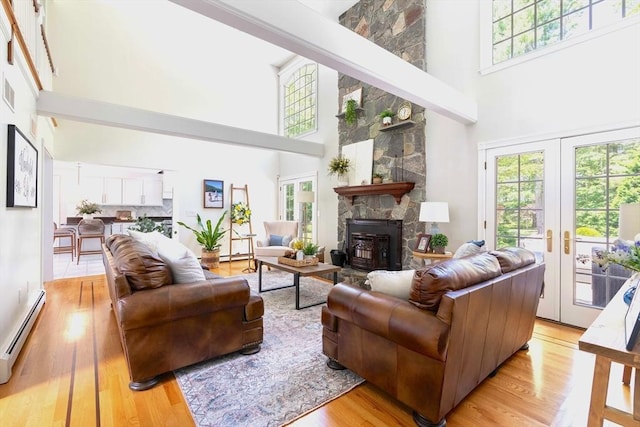 40 King Philip Dr, Rehoboth, MA 02769 - living area featuring a towering ceiling, baseboard heating, plenty of natural light, light wood-style flooring, and french doors
