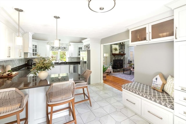 40 King Philip Dr, Rehoboth, MA 02769 - kitchen with a sink, a kitchen bar, decorative backsplash, dark countertops, and a peninsula