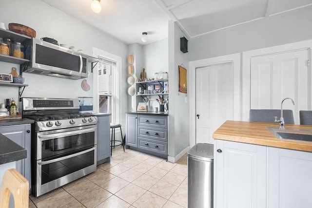 kitchen featuring sink, light tile patterned flooring, and appliances with stainless steel finishes