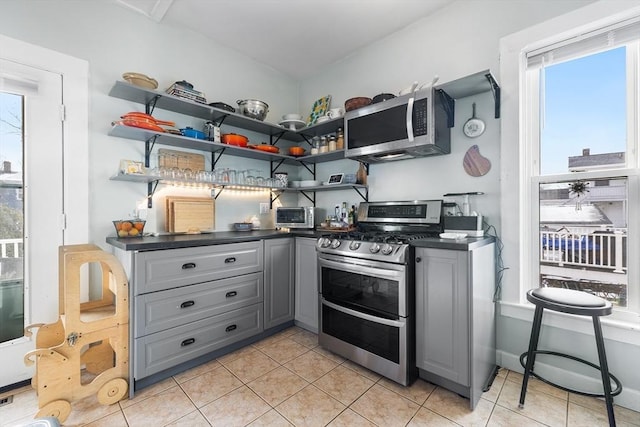 kitchen featuring stainless steel appliances, gray cabinetry, and light tile patterned floors