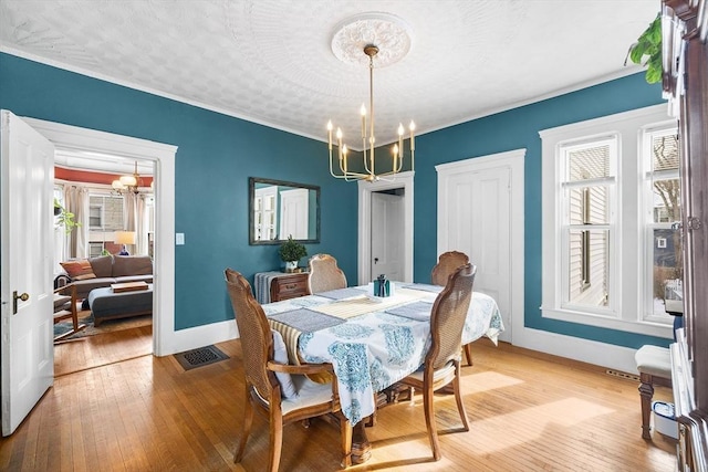 dining room featuring a wealth of natural light, a notable chandelier, and light hardwood / wood-style flooring