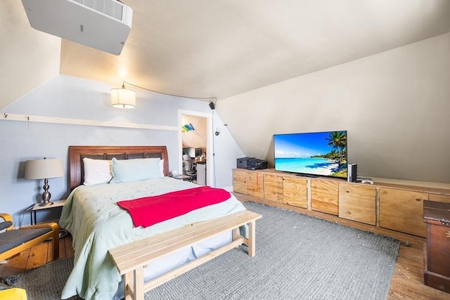 bedroom with hardwood / wood-style flooring and lofted ceiling