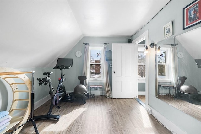 exercise area featuring vaulted ceiling and hardwood / wood-style floors