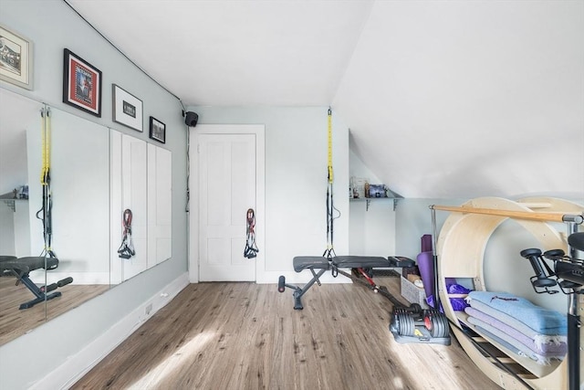 workout area featuring hardwood / wood-style flooring and lofted ceiling