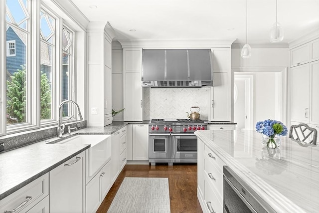 5 Stratford Rd, Winchester, MA 01890 - kitchen with range with two ovens, healthy amount of natural light, wall chimney range hood, white cabinets, and crown molding