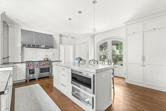 5 Stratford Rd, Winchester, MA 01890 - kitchen with double oven range, a warming drawer, wall chimney exhaust hood, backsplash, and white cabinetry