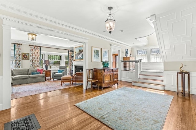5 Stratford Rd, Winchester, MA 01890 - sitting room with ornamental molding, wood finished floors, wainscoting, a chandelier, and a fireplace