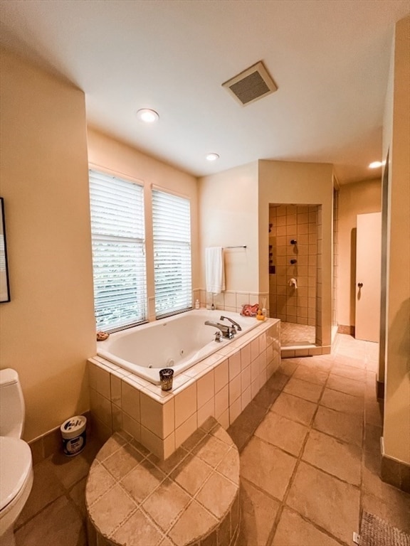 bathroom featuring toilet, shower with separate bathtub, and tile patterned floors