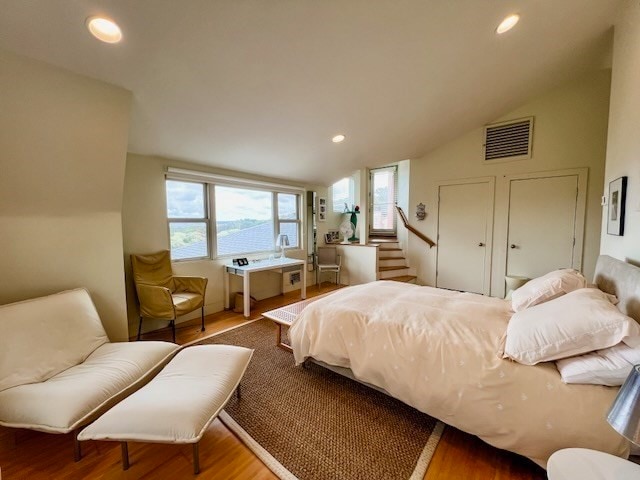 bedroom with lofted ceiling and wood-type flooring