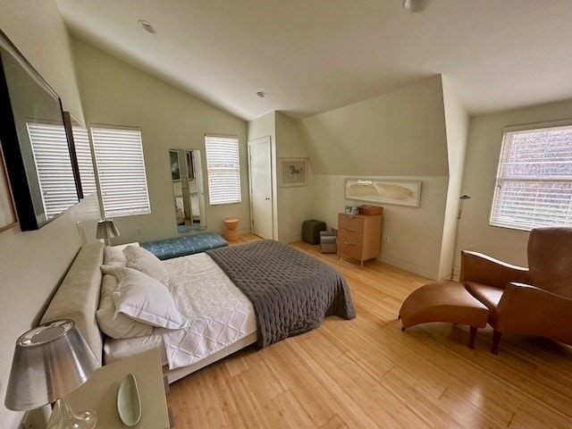 bedroom with light hardwood / wood-style floors and lofted ceiling