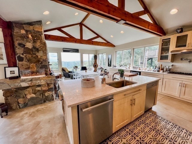 kitchen with appliances with stainless steel finishes, beam ceiling, a healthy amount of sunlight, and sink