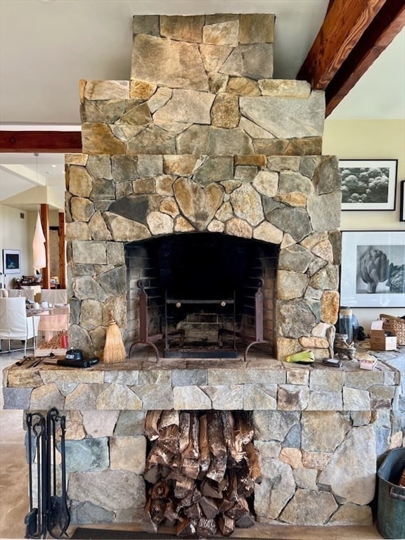 interior details with a stone fireplace and beamed ceiling