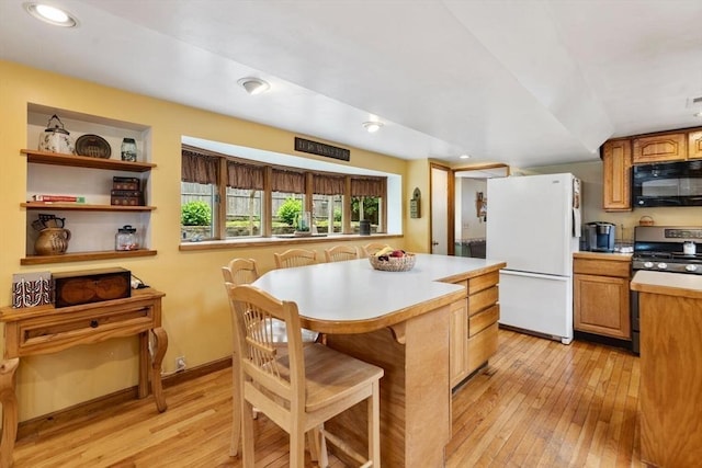 12 Clarner Rd, Lynn, MA 01904 - kitchen with freestanding refrigerator, black microwave, stainless steel gas range, light wood finished floors, and light countertops