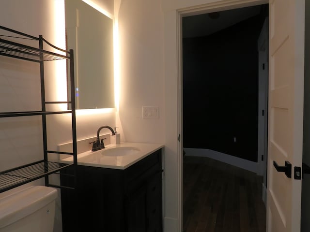 bathroom featuring hardwood / wood-style flooring, vanity, and toilet