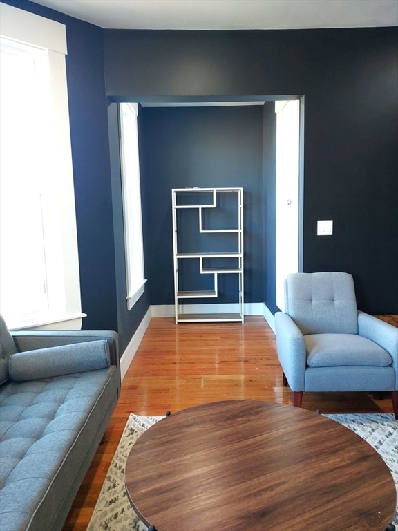 living room with dark hardwood / wood-style flooring and a healthy amount of sunlight