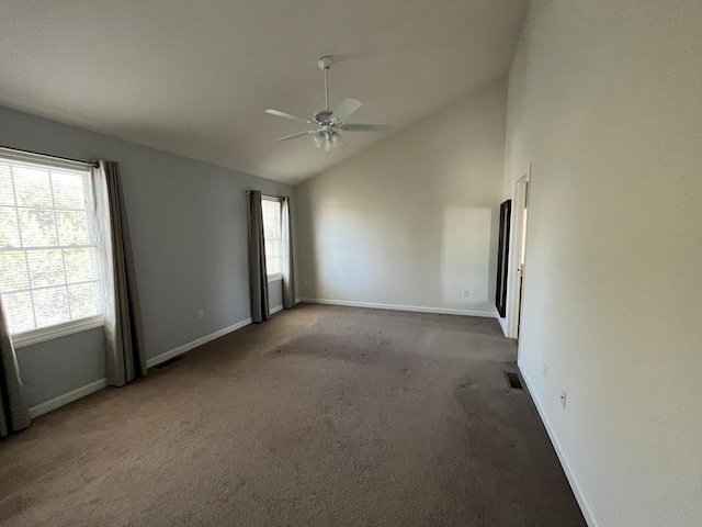 empty room featuring a ceiling fan, visible vents, vaulted ceiling, and a wealth of natural light