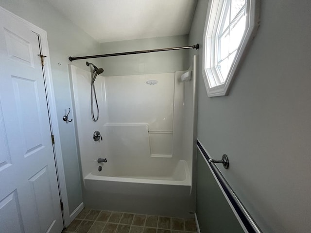 bathroom with washtub / shower combination and tile patterned flooring