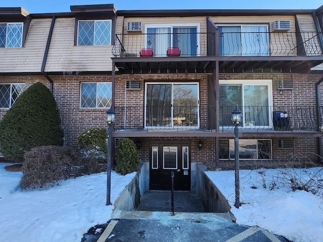 snow covered rear of property with a balcony