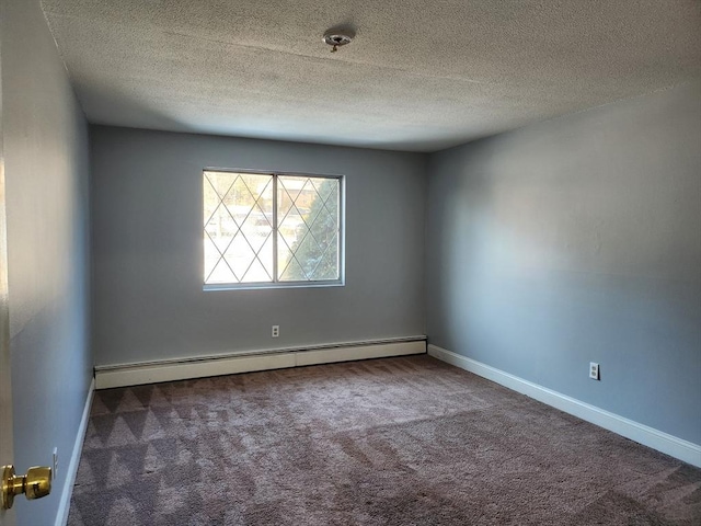 spare room featuring baseboard heating, a textured ceiling, and dark colored carpet