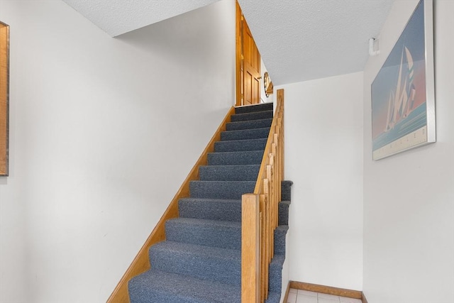36 Tobey Rd Unit 25, Dracut, MA 01826 - staircase with a textured ceiling, tile patterned floors, and baseboards