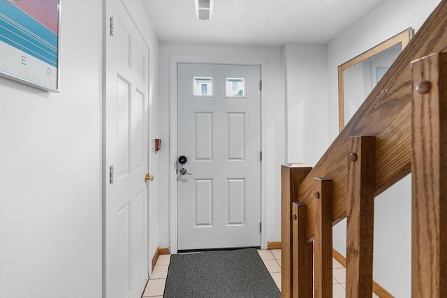 36 Tobey Rd Unit 25, Dracut, MA 01826 - doorway to outside featuring light tile patterned flooring, baseboards, and a textured ceiling