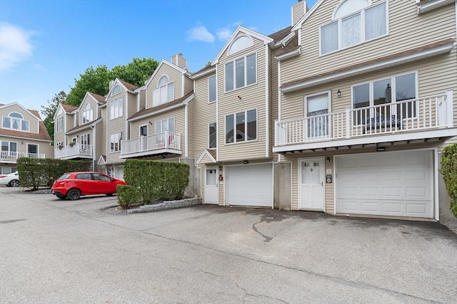 36 Tobey Rd Unit 25, Dracut, MA 01826 - view of front of home featuring a residential view, a chimney, an attached garage, and driveway