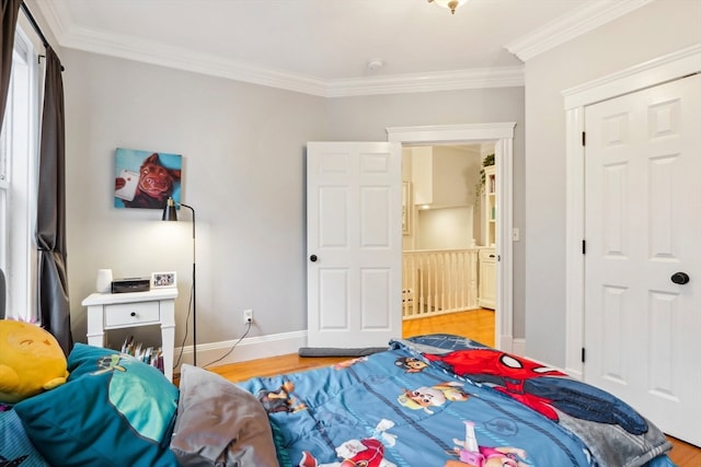 bedroom with crown molding, a closet, and light wood-type flooring