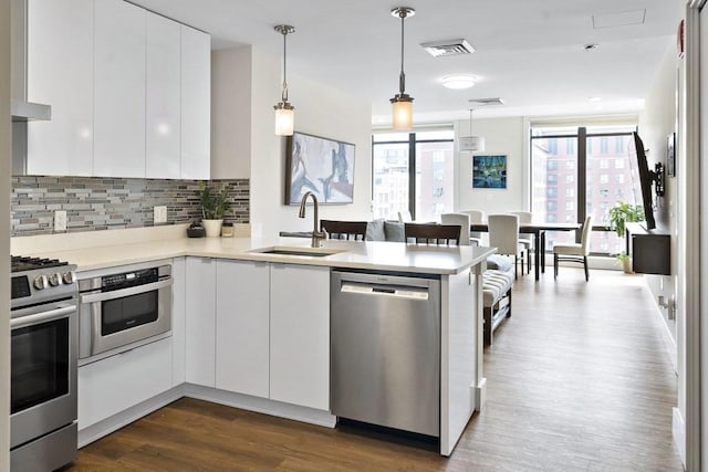 121 Portland St Unit 902, Boston, MA 02114 - kitchen with stainless steel appliances, modern cabinets, a peninsula, and dark wood-style flooring