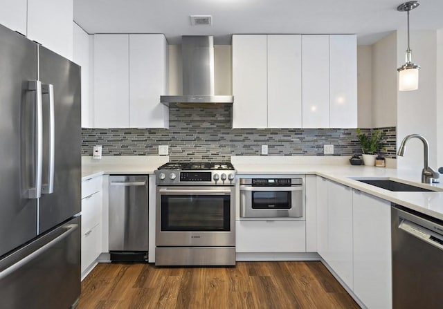 121 Portland St Unit 902, Boston, MA 02114 - kitchen with stainless steel appliances, wall chimney range hood, modern cabinets, light countertops, and dark wood-type flooring