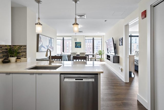 121 Portland St Unit 902, Boston, MA 02114 - kitchen featuring stainless steel dishwasher, light countertops, dark wood-style flooring, and backsplash