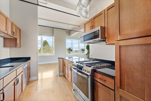 51 Lafayette St Unit 304, Salem, MA 01970 - kitchen featuring appliances with stainless steel finishes, light wood-style floors, brown cabinets, and baseboards