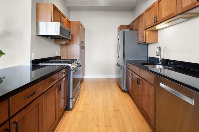 51 Lafayette St Unit 304, Salem, MA 01970 - kitchen featuring stainless steel appliances, a sink, brown cabinets, light wood-style flooring, and baseboards