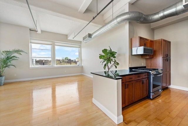 51 Lafayette St Unit 304, Salem, MA 01970 - kitchen featuring stainless steel range with gas stovetop, light wood finished floors, dark countertops, brown cabinetry, and baseboards